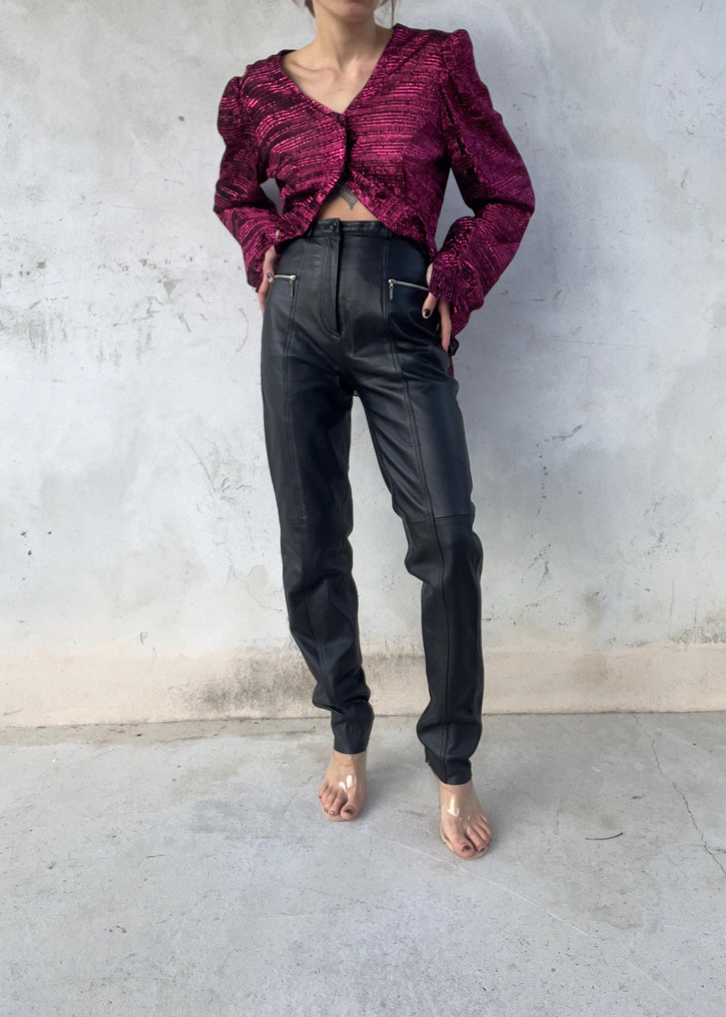 Pantaloni di pelle a vita alta dalla linea affusolata con tasche zip metalliche sul davanti