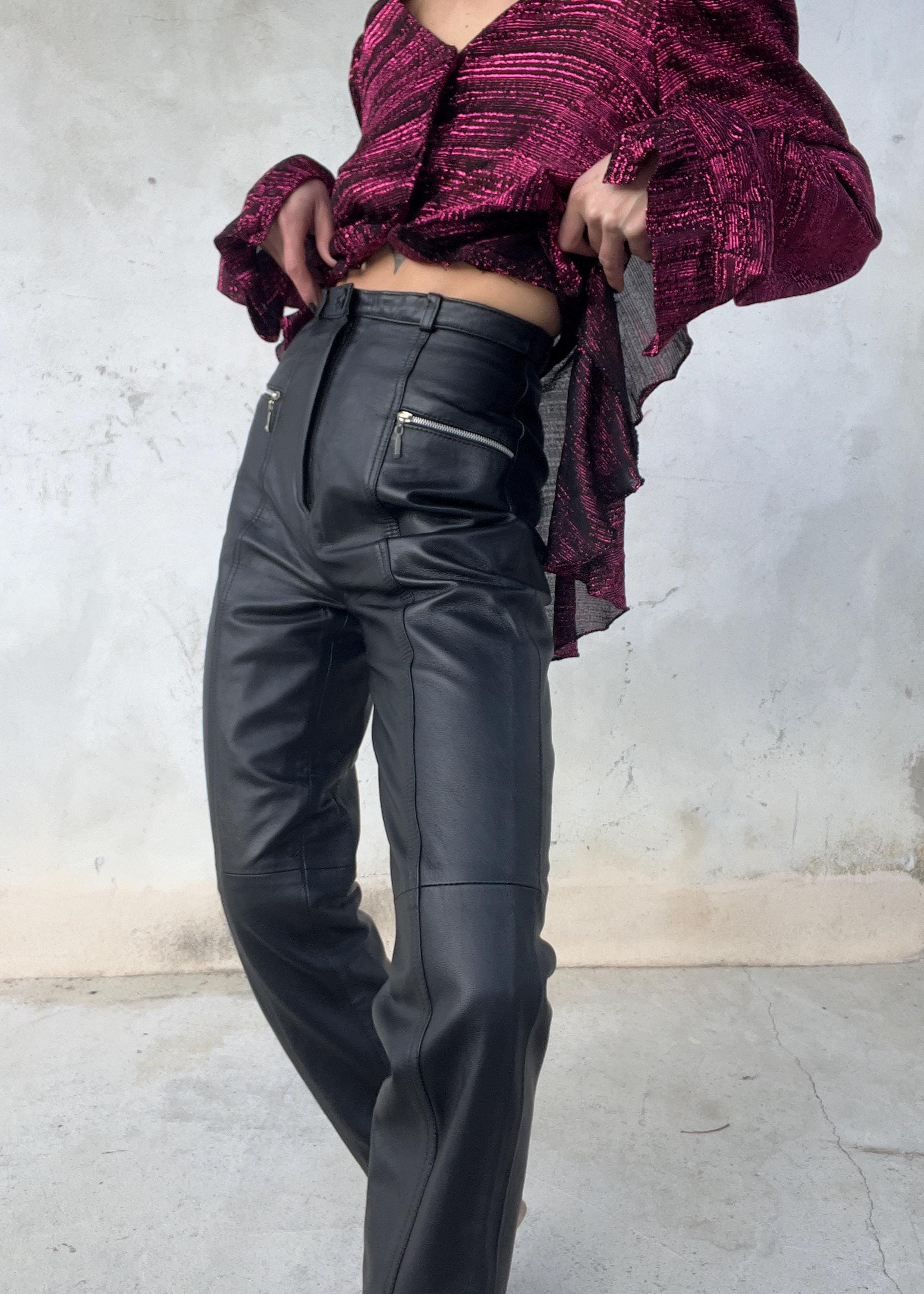 Pantaloni di pelle a vita alta dalla linea affusolata con tasche zip metalliche sul davanti