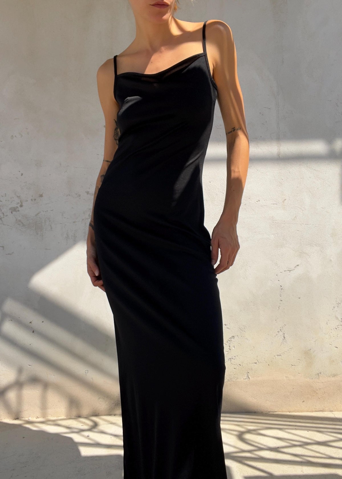 Abito lungo nero dal design minimal con delicato scollo drappeggiato e sottili spalline