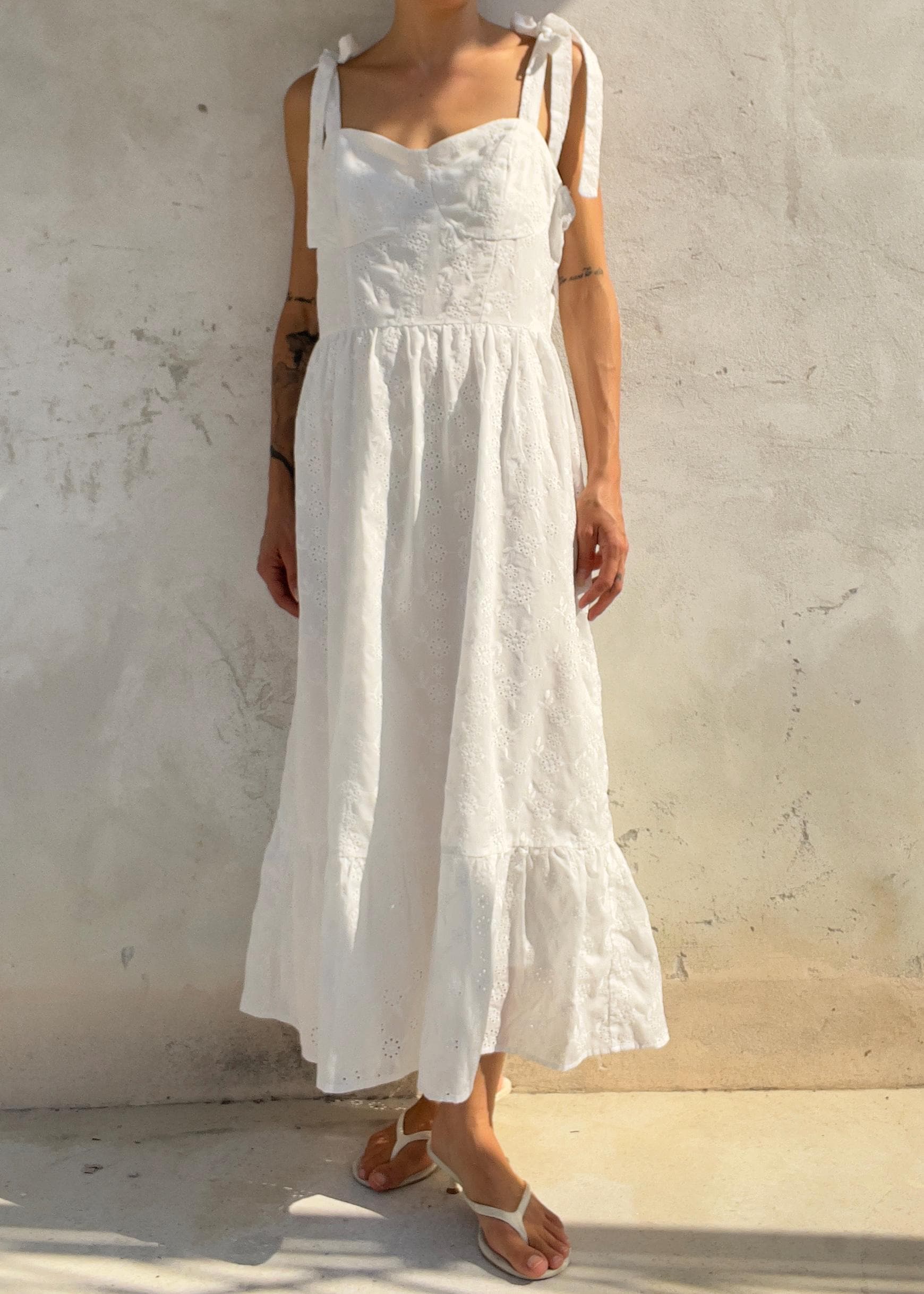 Abito midi in cotone bianco con ricami traforati e dettagli con lacci sulle spalle: abito estivo in
