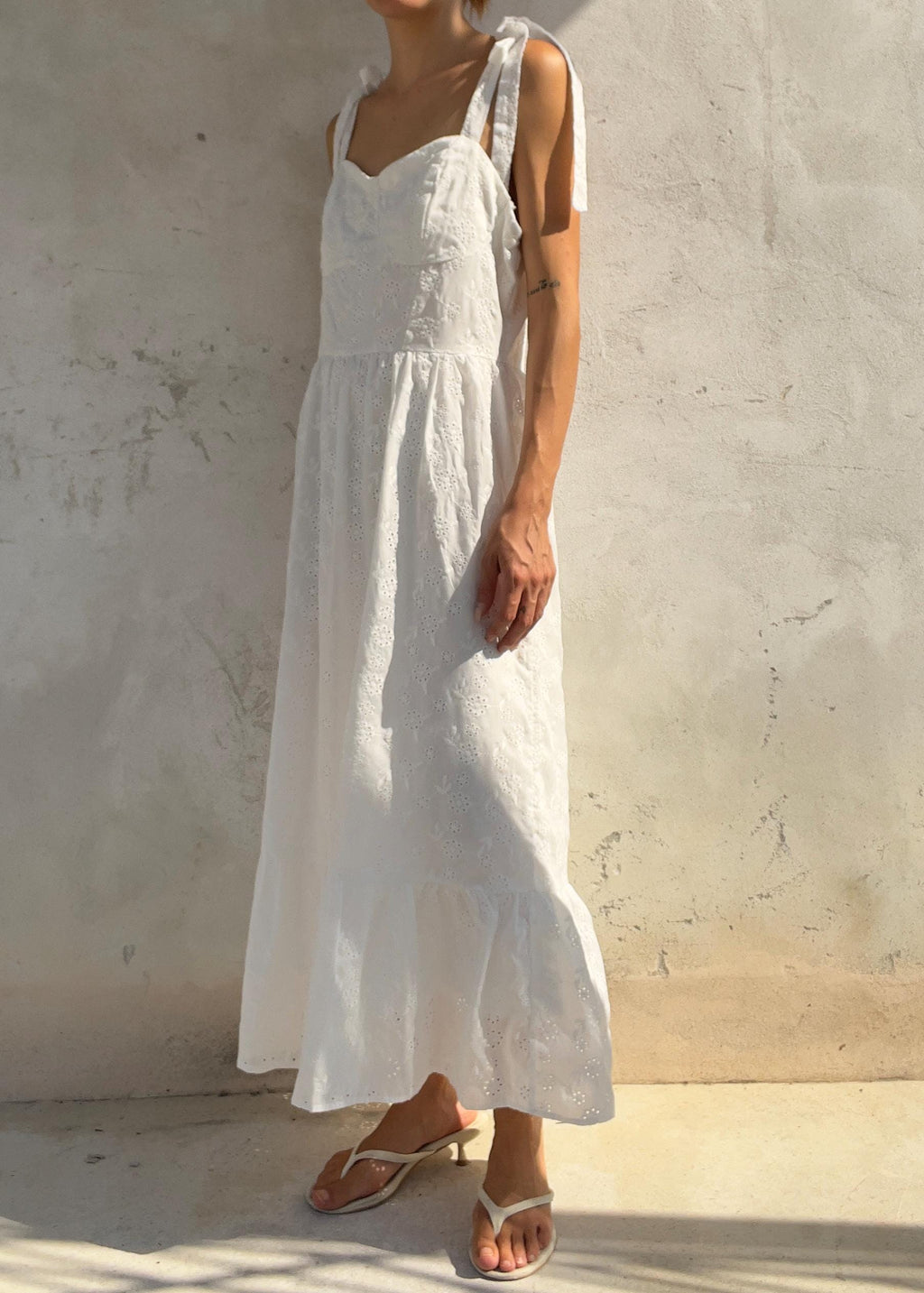 Abito midi in cotone bianco con ricami traforati e dettagli con lacci sulle spalle: abito estivo in