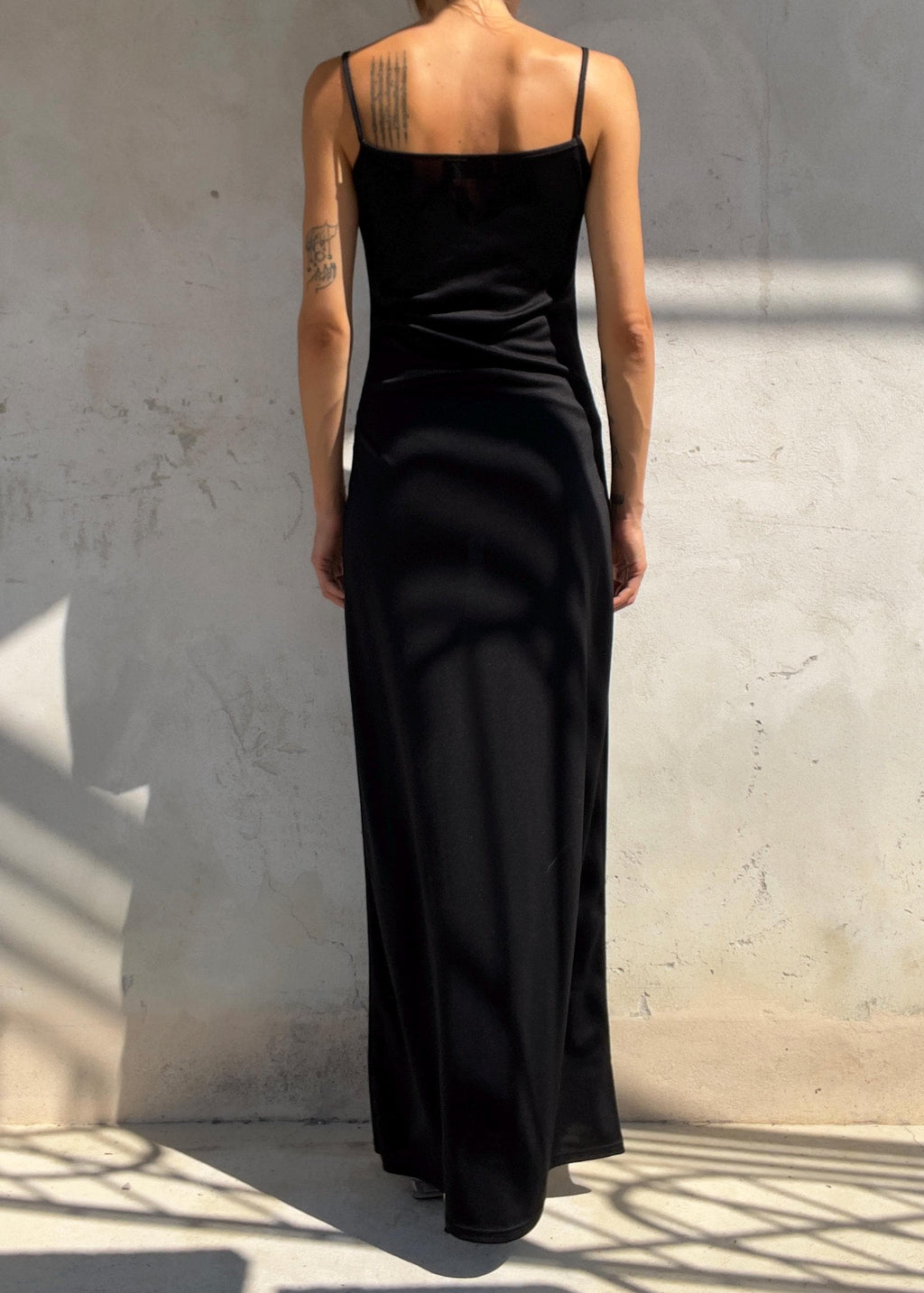 Abito lungo nero dal design minimal con delicato scollo drappeggiato e sottili spalline